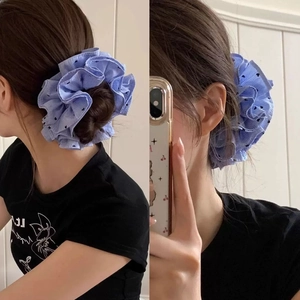 Blue striped oversized scrunchie with heart patterns worn on a casual hair bun