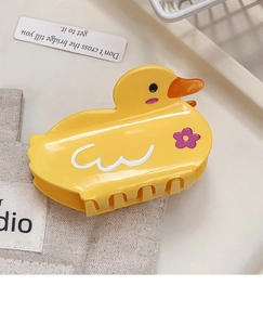 Detailed view of yellow duck hair claw clip with purple flower and smooth finish