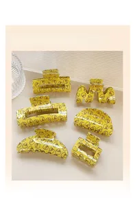 Set of six yellow hair claw clips with cute cartoon duck patterns in various shapes