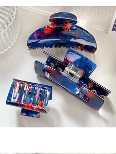 Detail view of blue nebula pattern hair claws in semicircular and rectangular shapes