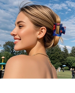 Close-up of marble patterned hair claw clip on model in outdoor sunlight