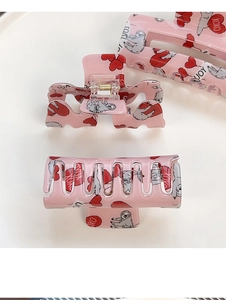 Détail de pinces à cheveux roses avec motifs de cœurs et mignonnes illustrations de paresseux