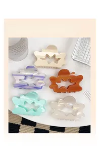 Detailed set of 5 colorful acetate cloud hair claws with star cutouts on a white tray