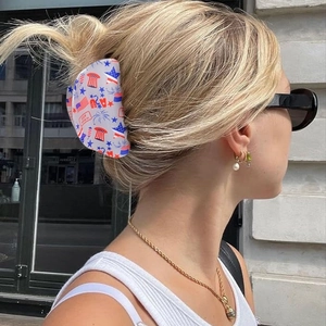 Star hair claw clip with USA flag patterns worn on a woman's blonde hair bun