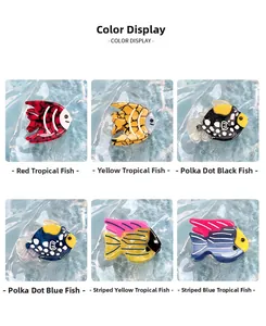 Detail showing 6 colors of acetate fish hair clips with marble patterns on blue water background