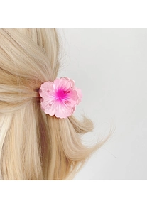 Detailed view of a pink gradient plumeria hair claw clip on blonde hair for a summer look