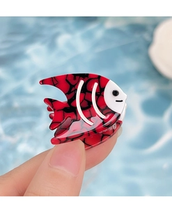 Detailed macro view of an orange and black acetate tropical fish hair clip