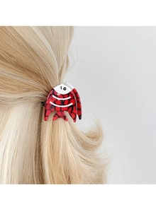 Detailed view of the fish-shaped acetate hair claw clip worn on long blonde hair