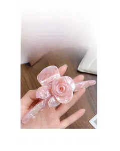 Detailed macro view of a large acetate pink rose hair claw with elegant marble texture