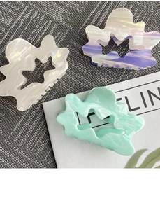 Detail of hollow cloud hair claws in pearl white, gradient purple, and marble mint green