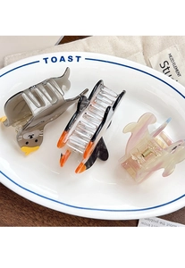 Detail view of cartoon seal and penguin acetate hair claws in a ceramic tray