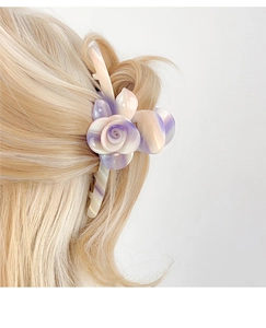 Detail view of purple marble-textured acetate rose flower claw clip on blonde hair