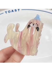 Macro view of a cute marble pink walrus hair claw clip with detailed facial features