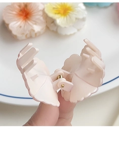 Macro view of pink plumeria hair claw clip showcasing teeth and metal spring