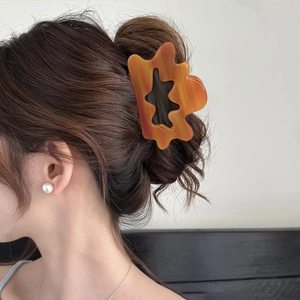 French style amber resin hair claw clip with hollow cloud design on female model