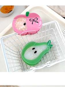 Détail de pinces à cheveux en acétate en forme de pomme rose et de poire verte