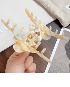 Detailed view of large marbled orange acetate hair claw with unique antler design