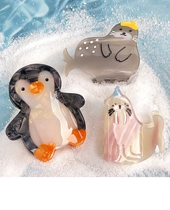 Detailed view of sea lion penguin claw clips made of premium acetate on white sand