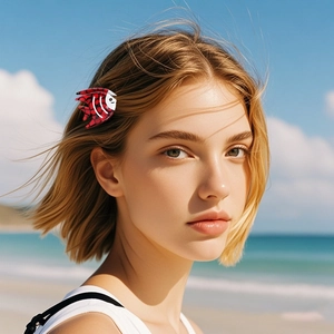 Fish shaped acetic acid hair clip with red and black pattern worn by model at beach