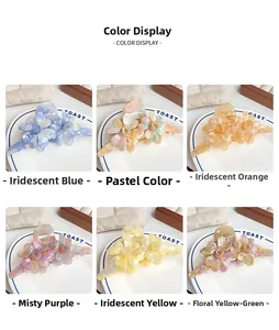 Détail de grandes pinces à cheveux fleur en acétate disponibles en six couleurs vives