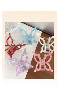 Close-up of five colorful oversized butterfly hair claw clips with pearls and rhinestones