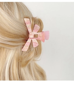 Detail of pink marble butterfly hair claw clip worn on hair with a metallic spring