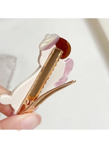 Detailansicht der goldenen Metallklammer und des Cartoon-Haarclips aus Harz