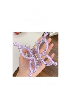 Detailed view of a purple butterfly hair claw with rhinestones and pearl accents