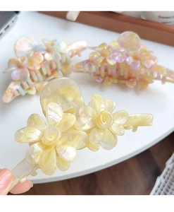 Détail de la pince à cheveux fleur 3D en acétate avec finition nacrée élégante