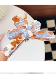 Detail of the marbled acrylic hair claw clip with large bow shape and strong metal spring