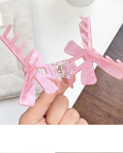 Detail of pink marble textured acrylic claw clip showing open metal spring structure