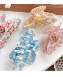 Detailed close-up showing four textured acetate tulip flower hair claw clips with patterns