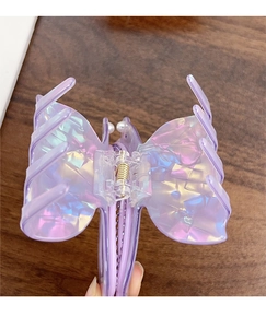 Detail of a large pearlescent butterfly hair claw clip with purple hue and pearls