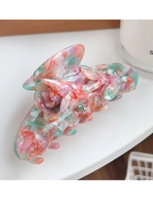 Detailed macro view of large 3D tulip hair claw with pink and green marble resin texture