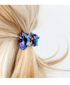Detailansicht einer süßen Haarspange in Katzenform aus blauem Acetat auf blondem Haar