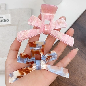 Acrylic bow hair claw clips in pink glitter and tortoise patterns for elegant women's styling