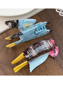Detail of bird-shaped acetate hair claws in blue marble and colorful bird patterns