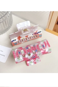 Detailansicht der rosa Blumen-Haarklammern aus Resin mit Blumendruck und goldener Feder