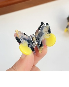 Detail einer Mini-Schmetterlings-Haarklammer mit Schildpattmuster und Metallfeder