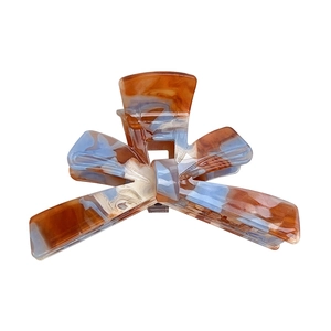 Elegant large acrylic bow hair claw clip with brown and blue marble pattern