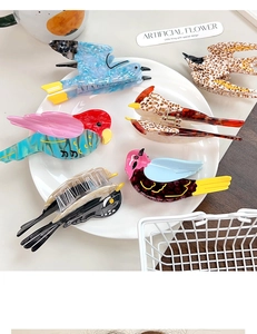 Detailed macro view of assorted bird-shaped acetate hair claws in various vibrant colors