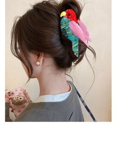 Detail of colorful parrot hair claw clip made of acetate worn on a bun hairstyle