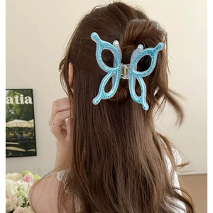Oversized blue butterfly hair claw clip with rhinestones worn on a woman's hair