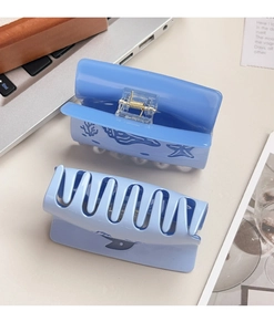 Detail showing two light blue ocean pattern claw clips with starfish and seashell prints