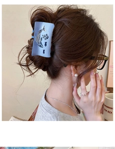 Blue ocean-themed hair claw featuring cut-out dolphin and coral designs in acetate