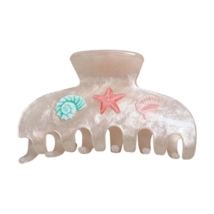 Pince à cheveux étincelante sur le thème de la mer avec étoile de mer et coquillage