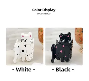 Détail de pinces à cheveux chat mignonnes en acétate brillant noir et blanc à motifs
