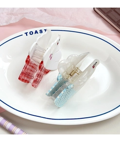 Close-up of heart and rabbit ear hair clips with checkered pattern on a white plate