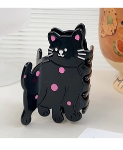 Détail d'une pince à cheveux noire en acétate avec un motif chat mignon et pois roses
