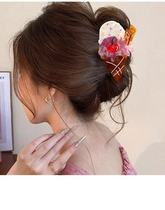 Detail of creative ice cream hair claw clip with cherry decor worn on hair